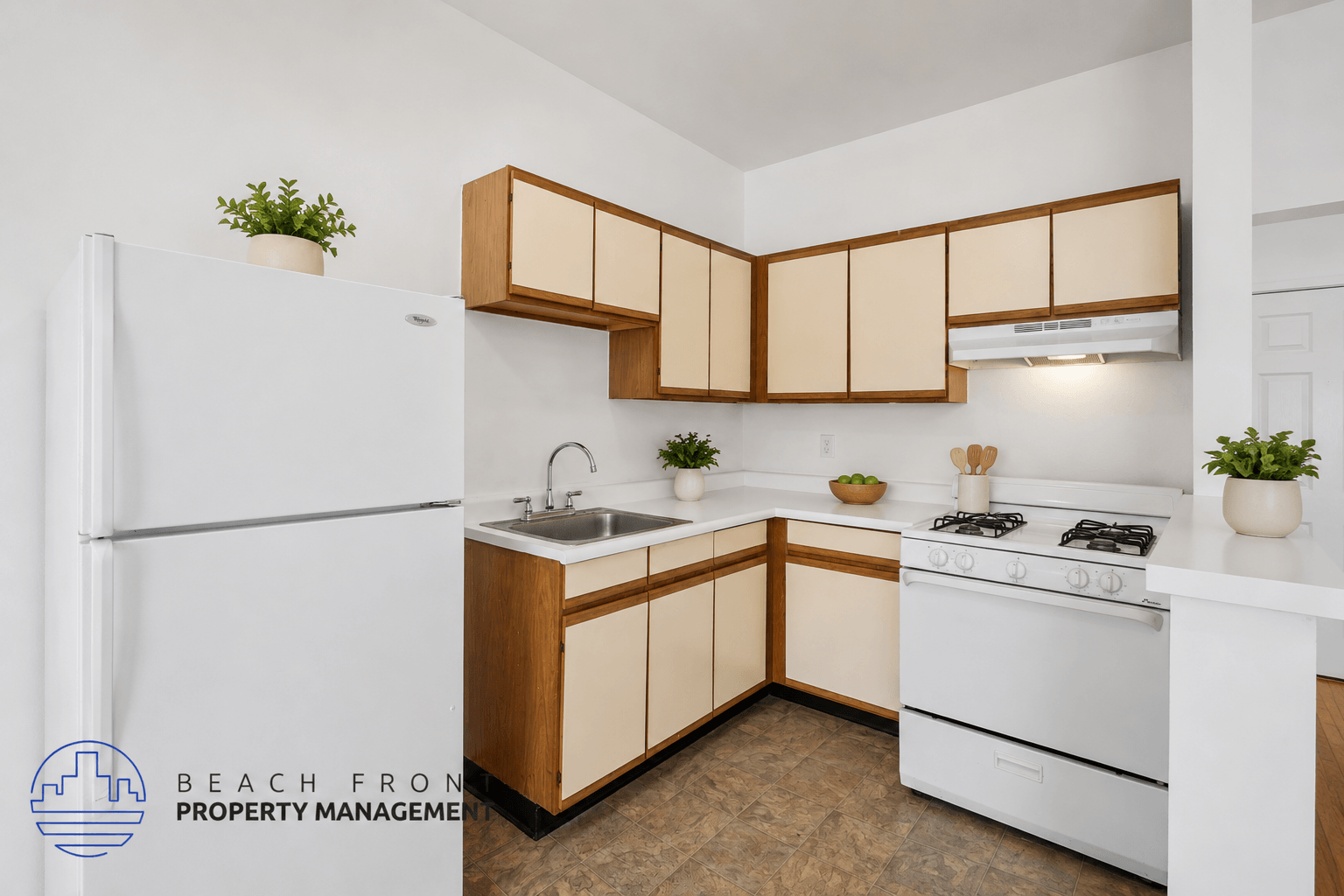 A kitchen with wooden cabinets and a white stove top oven.